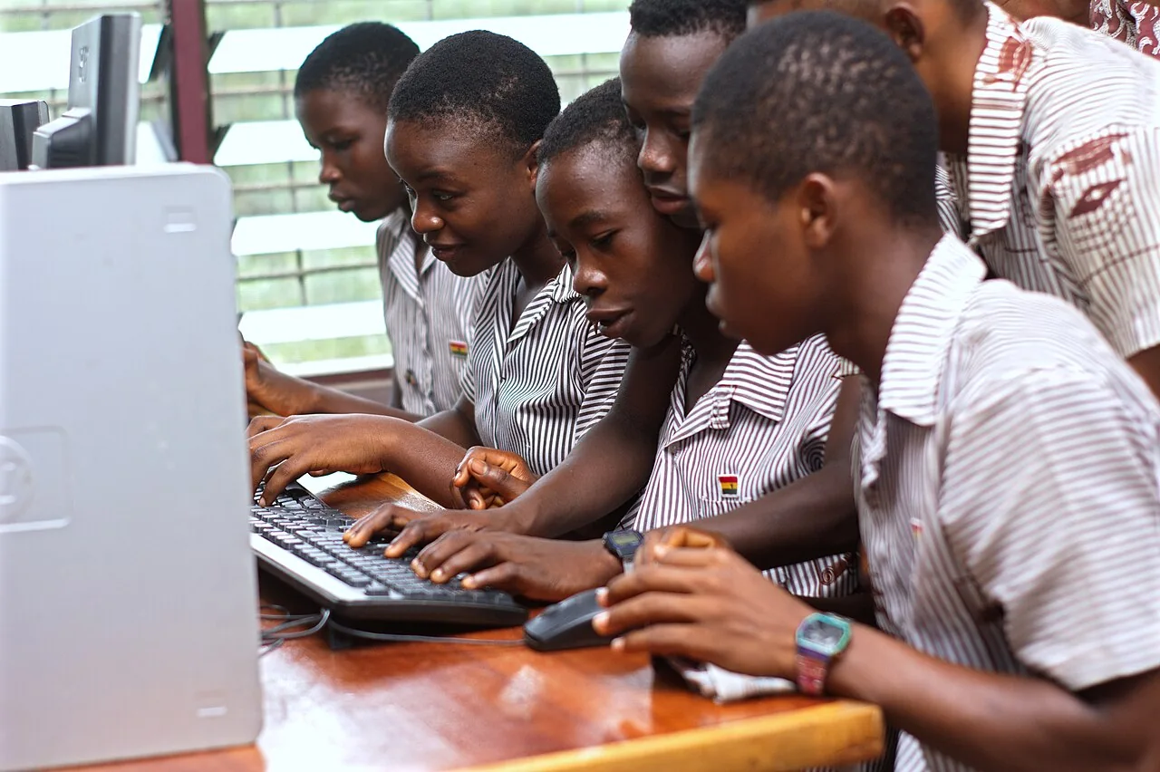 Students in Ghana working together at a school computer